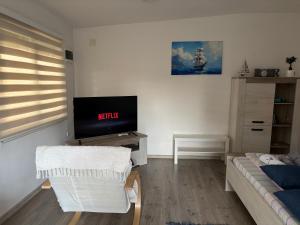 a living room with a tv and a couch at Full House in Bečej +6 photos