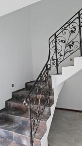 a staircase with wrought iron railings and a white wall at Villa EL&ES in Ciężkowice