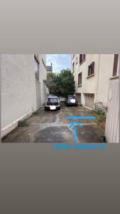 two cars parked in a parking lot next to a building at Havre de sérénité coeur de Dijon in Dijon +13 photos