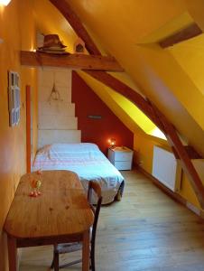 a bedroom with a bed and a wooden table at Gîte 3 chambres dans Longère aux Rosiers-sur-Loire in Le Thoureil