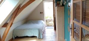 a bedroom with a bed in a room with a window at Gîte 3 chambres dans Longère aux Rosiers-sur-Loire in Le Thoureil
