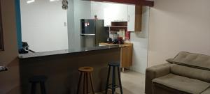 a kitchen with a counter and a bar with stools at Casa do Caiçara in Ubatuba