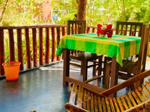 a table with a green and yellow table cloth on a porch at La Casa Safari Resort in Udawalawe +42 photos