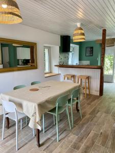 a kitchen and dining room with a table and chairs at Gîte "La petite pompe" avec piscine et spa in Prissac
