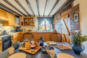 a kitchen with a table with food on it at Maple Cottage - Rural Charm & Cotswold Views in Dumbleton
