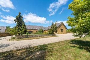 an external view of a house with a driveway at Greenhill Farm Barn- Stunning Cotswold Barn with Billiards Room in Sutton under Brailes