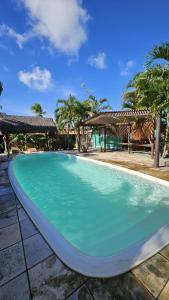 a swimming pool with blue water in a resort at Hawaii Flats in São Miguel do Gostoso