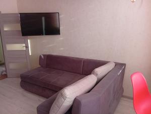 a living room with a brown couch and a flat screen tv at Апартаменты у моря м Южне in Sychavka
