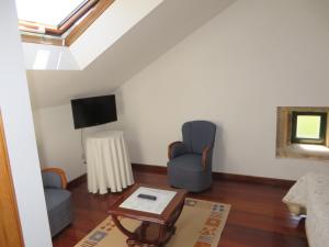 a living room with two chairs and a tv at Casa da Roncha in Noya