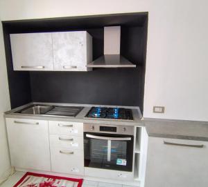a small kitchen with a stove and a sink at Casina del Sole - Rho Fiera Milano in Bollate