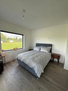 a bedroom with a large bed and a large window at Boskill Equestrian Centre Guesthouse in Limerick
