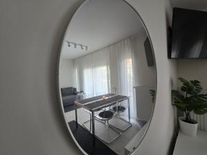 ニエホジェにあるUroczy apartament blisko plaży i latarni Niechorzeのリビングルーム(テーブル付)を反映した鏡