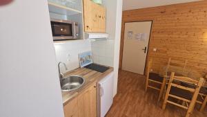 una piccola cucina con lavello e microonde di Orelle 3 Vallées - Studio 4 personnes a Orelle 1 altra foto