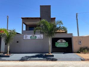 a restaurant with palm trees in front of a building at Pousada Paraíso Goiânia in Goiânia