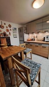 eine Küche mit einem Holztisch und Stühlen in der Unterkunft Ciurkówka in Sieniawa