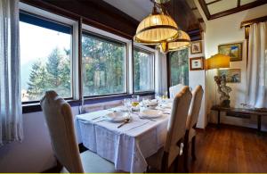 a dining room with a table and some windows at Villa Virginia Calalzo di Cadore in Calalzo