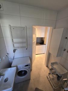 ニエホジェにあるUroczy apartament blisko plaży i latarni Niechorzeの洗濯機と洗面台を備えたバスルーム