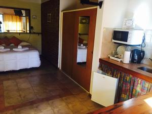 a hotel room with a bed and a microwave at Apart Hotel TY Coed in Puerto Madryn