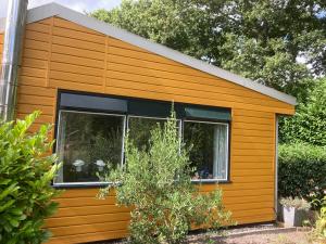ein kleines orangefarbenes Haus mit einem Fenster in der Unterkunft Leentjes plek in Hoogersmilde