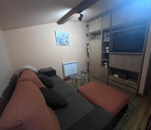 a living room with a couch and a flat screen tv at La casina de la Texa in La Sestal