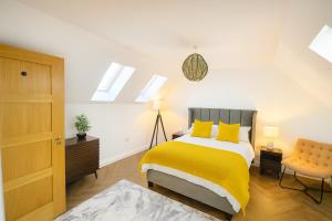 Spinney HillにあるNorthampton 3 Bed 3 Bathroom New Duplex Apartmentの黄色い枕が置かれたベッドのある寝室