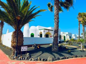 eine Gruppe von Palmen vor einem Gebäude in der Unterkunft Villa Karisa in Playa Blanca