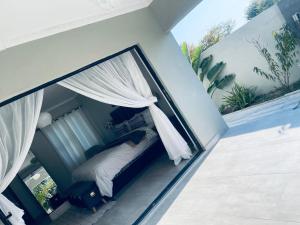 a bedroom with a canopy bed on a balcony at Luna Holiday Home in Maun