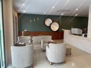 a waiting room with white chairs and a counter at S-room Scentral Hatyai in Hat Yai