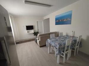 a living room with a dining room table and a couch at Brisa Do Mar - Consolação in Peniche