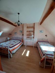 una camera da letto con 2 letti e una scrivania in mansarda di GITE "La Bournillière" a Vicq-sur-Nahon