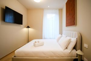 a bedroom with a white bed with a window at Balcony Double Suite - 3 min walk to Bernina Express in Tirano