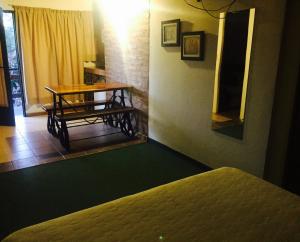 Cette chambre comprend une table et une table avec un miroir. dans l'établissement Apart Hotel TY Coed, à Puerto Madryn