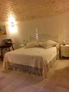 ImpalataにあるIl Trullo di Giuliettaのベッドルーム1室(白いベッドカバー付)