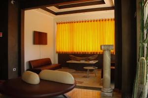 a living room with a table and a yellow curtain at Hotel L'AQUILA 99 in LʼAquila