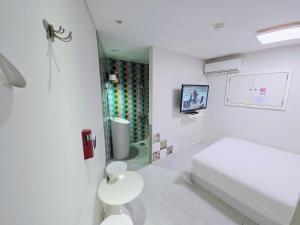a white room with a bed and a table at Navi hotel in Seoul