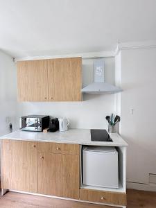 Una cocina con gabinetes de madera y encimera. en Central Spot - Louise, en Bruselas