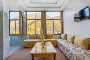 a living room with a couch and a table at Retraite Panoramique sur l'Atlas in Ourika