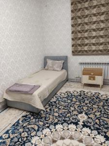 Un dormitorio pequeño con una cama y una alfombra. en Apartement in Bukhara, en Bukhara