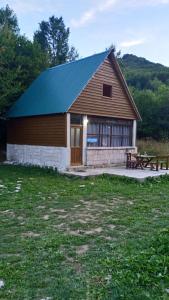 a barn with a picnic table and a bench at -DO- Gradac in Šavnik