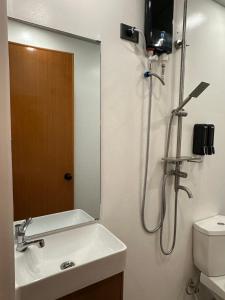 a bathroom with a shower and a sink and a mirror at Madayao Villa in El Nido