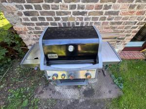 a grill sitting in front of a brick wall at Remise an der Rennbahn - 30 Minuten zum Alexanderplatz und doch im Grünen in Hoppegarten