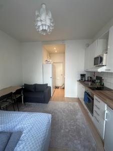 a kitchen and living room with a bed and a couch at Prime CityNest in Helsinki
