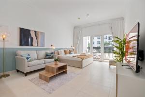 a living room with a couch and a tv at Elegant Studio with Yas Views in Abu Dhabi