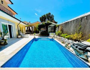 a swimming pool in the backyard of a house at Sunrise Villa Alvorada - Orchard Lookout in São Miguel