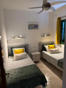 ein Schlafzimmer mit zwei Betten und einem Deckenventilator in der Unterkunft Villa Karisa in Playa Blanca + 25 Fotos