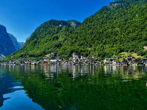 a village on the shore of a lake with mountains at Neuhaus Apartments in Gosau