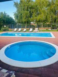 a large swimming pool with a blue pool at Tenisz vendégház in Ordacsehi