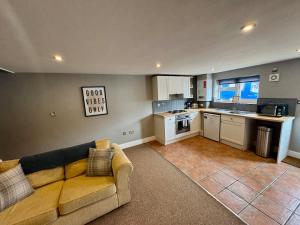 a living room with a couch and a kitchen at Sunset Cottage in Hunstanton