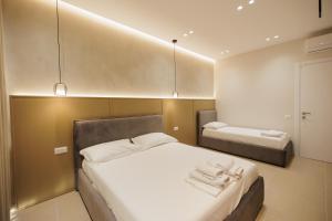 a bedroom with two beds with white towels on them at Kevin & Endri Luxury Apartment Kalaja Vlore in Vlorë +104 photos