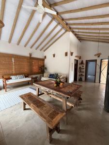 a large room with a wooden table and a couch at Samaya Corumbau in Corumbau